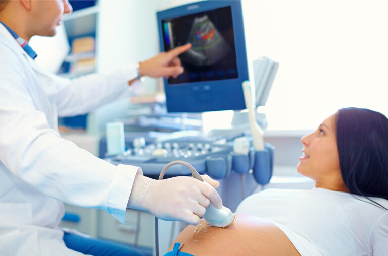 Sonographer performing ultrasound on pregnant woman